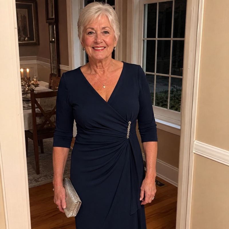 Woman wearing a navy wrap dress with a beaded waist detail
