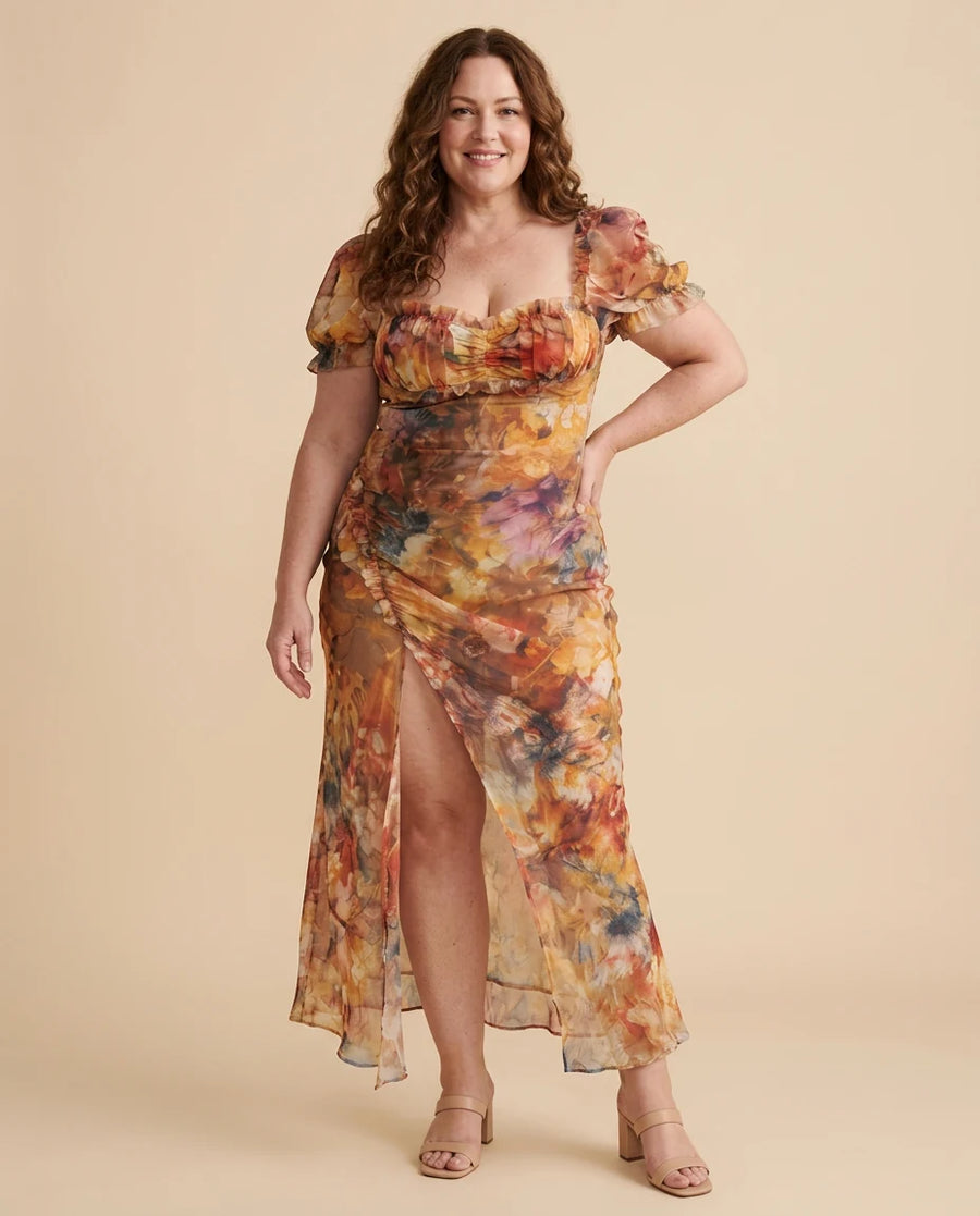 Ciel | Ruffled Sleeve Ruched Slit Midi Dress worn by a woman with curves