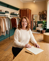 Clara, co-founder of Clara & June Boutique, at the table in the boutique with a handwritten letter