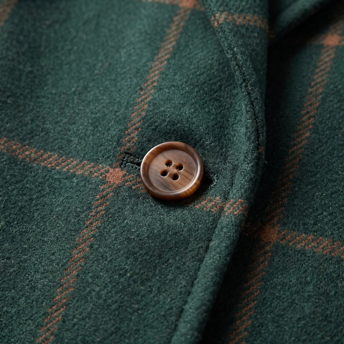 Close-up of the Coralie coat's checkered pattern and button