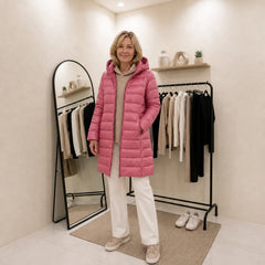 Woman wearing the Fiona puffer coat in pink with the hood down