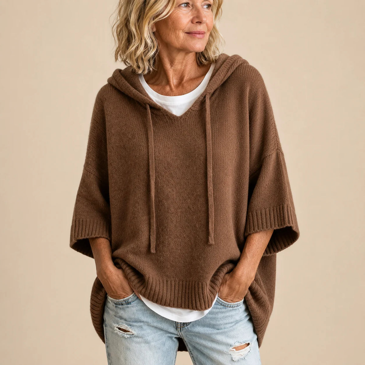 Woman wearing the Ottavia poncho in brown with the hood up