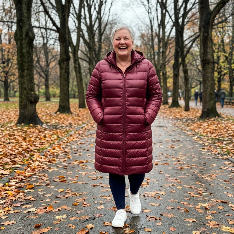 Customer wearing the Fiona hooded puffer coat in burgundy in an autumn park