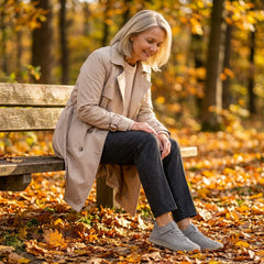 Rosie sneakers in gray, worn on a park bench