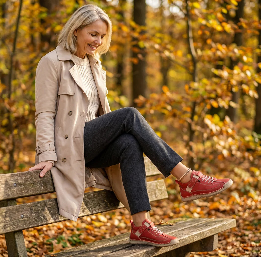 Rosie sneakers in red, worn while relaxing on a bench